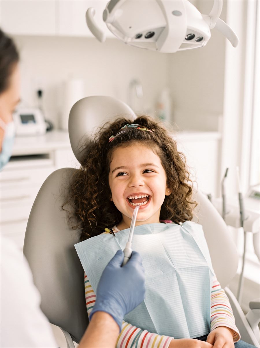 Uśmiechnięte dziecko podczas wizyty w gabinecie DENTIQ